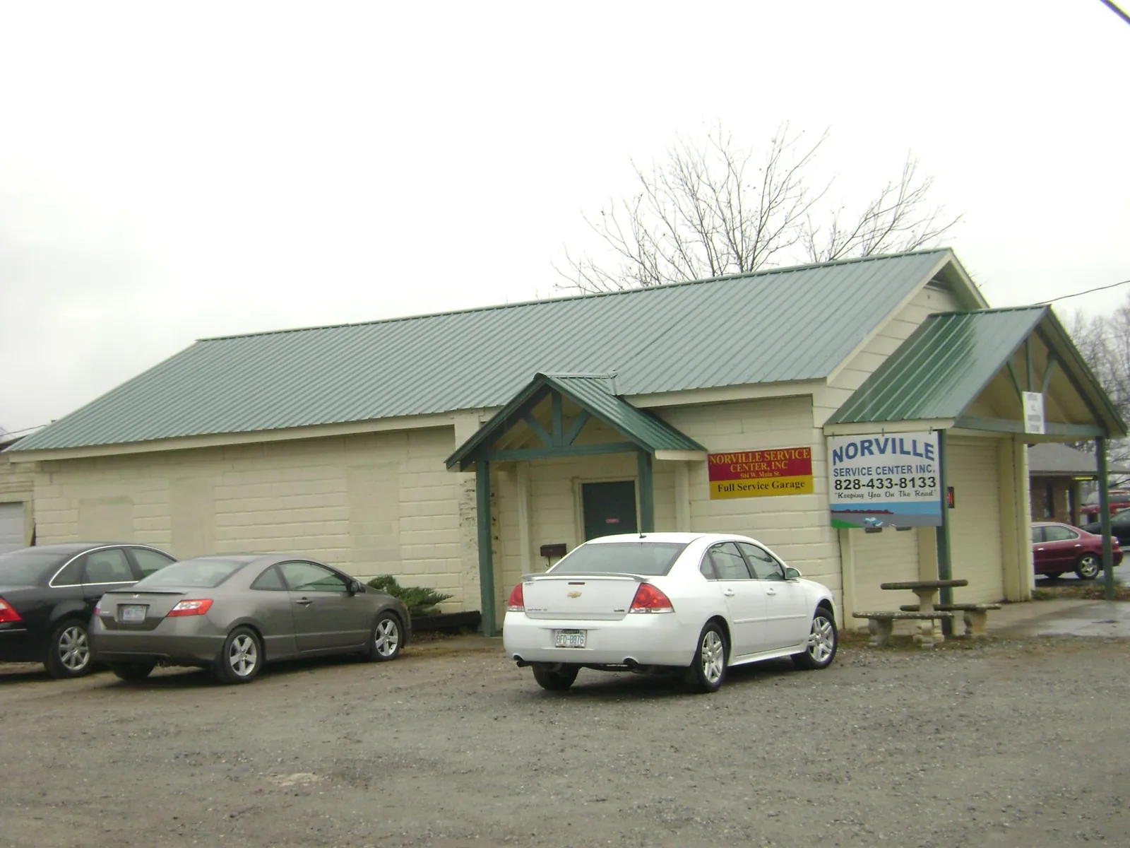 Green metal roof on a service garage with a covered entry in Bethany